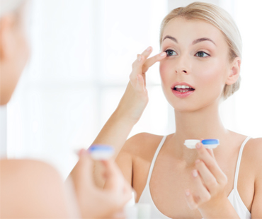 Woman inserting contact lenses